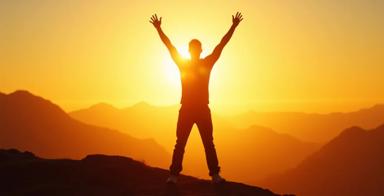 Person in aufrechter, kraftvoller Körperhaltung mit ausgestreckten Armen in natürlicher Umgebung